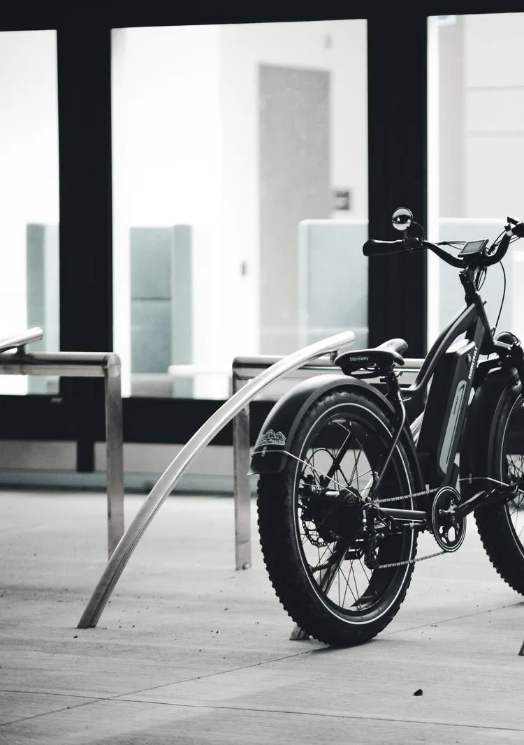 Schwarzes E-Bike in einer minimalistischen, nächtlichen Architekturkulisse